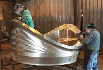 Within WFI International, two operators are putting the final touches on a 72 NPS Sweepolet® made of 304 stainless steel. This product is an integrally reinforced branch connection which restores full strength to the pipe in which it is installed. Within WFI International, two operators are putting the final touches on a 72 NPS Sweepolet® made of 304 stainless steel. This product is an integrally reinforced branch connection which restores full strength to the pipe in which it is installed.